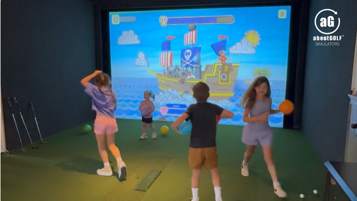 Kids playing an interactive pirate ship game on a simulator screen